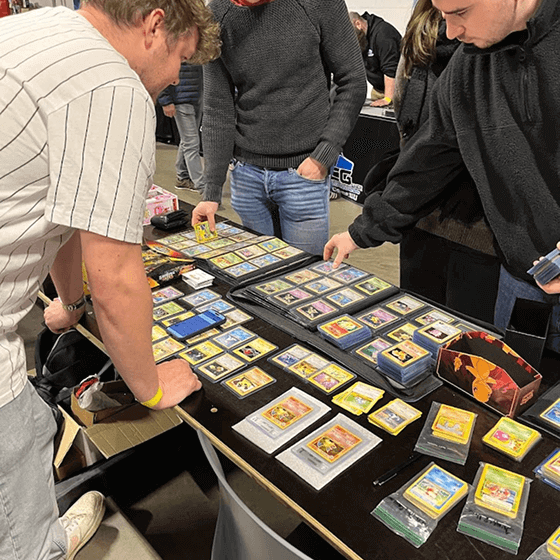 Mensen die kaarten ruilen bij een standhouder